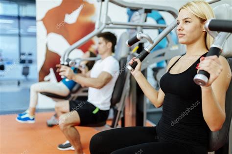 Persona joven sonriente haciendo ejercicio en un gimnasio comunitario para mujeres.
