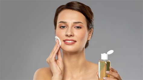 Imagen de una persona aplicando tónico facial con un algodón.