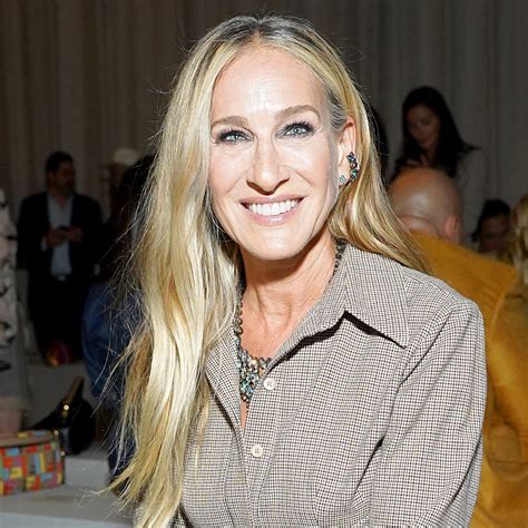Sarah Jessica Parker sonriendo, luciendo un estilo elegante y saludable.