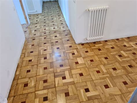 Detalle de un suelo de parqué de roble con signos de uso y desgaste.