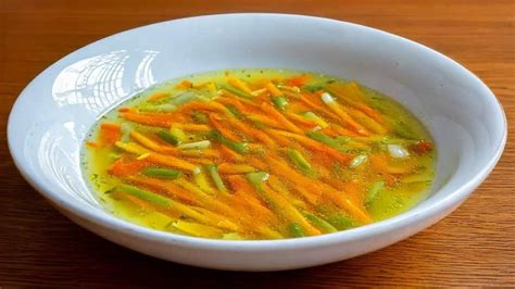 Ilustración de un plato de sopa juliana con verduras frescas y un semáforo nutricional superpuesto.