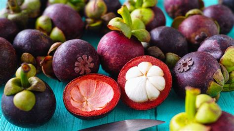 Detalle de la estructura del fruto del mangostán: corteza morada y pulpa blanca segmentada.