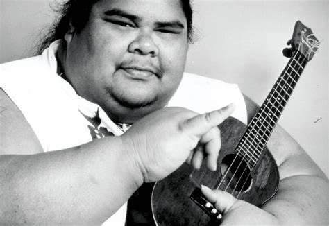 Israel Kamakawiwoʻole sonriendo y tocando el ukelele