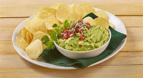 Dip de aguacate cremoso servido en un bowl con totopos de vegetales