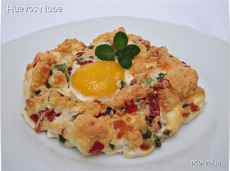 Huevos nube horneados, con las claras doradas y las yemas tiernas, decorados con cebollino.