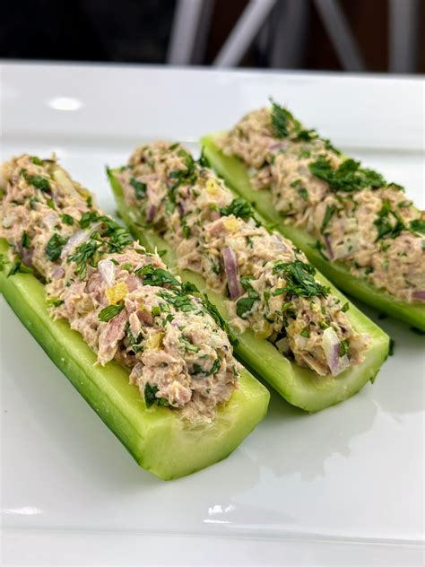 Barquitos de pepinillo rellenos de ensalada de atún, decorados con pimentón y eneldo.