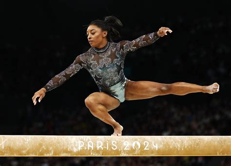 Foto de Simone Biles en acción, mostrando su musculatura y potencia