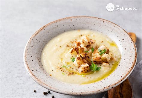 Imagen de un bol de crema de coliflor y puerro decorada con champiñones.