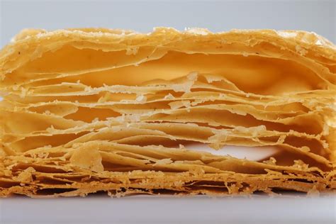 Ilustración de un milhojas francés perfectamente cortado, mostrando las capas de hojaldre y crema.