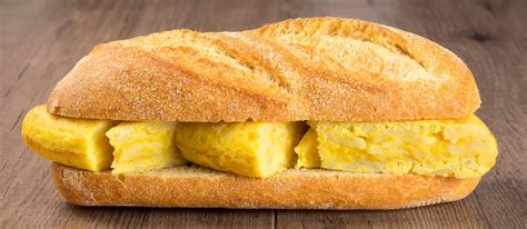 Ilustración de un bocadillo de tortilla española junto a un vaso de agua, con una señal de advertencia