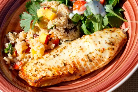 Ejemplo de un plato de comida equilibrada con pescado, ensalada y quinoa.