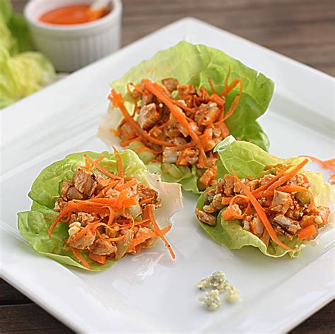 Lonchera con rollitos de lechuga rellenos de ensalada de pollo y frutas.