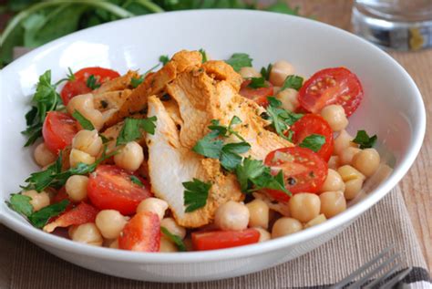 Un plato de ensalada colorida con pollo y garbanzos.