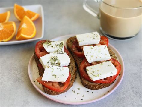 Ilustración de los ingredientes frescos para la tostada: tostadas integrales, queso fresco, tomate y romero.