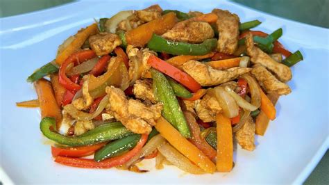 Salteado de pollo con pimientos de colores, calabacín, zanahoria y setas, presentado en un wok o plato.