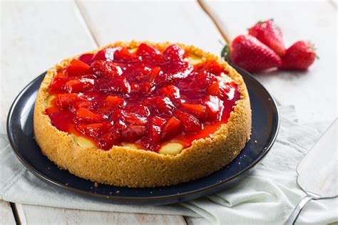 Una tarta de queso keto recién horneada, decorada con fresas.