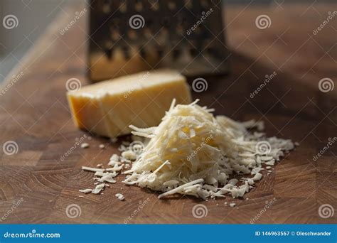 Imagen de un bloque de queso parmesano con un rallador