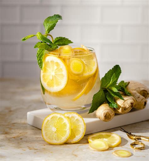 Fotografía de una jarra de agua de jengibre casera con rodajas de jengibre y limón