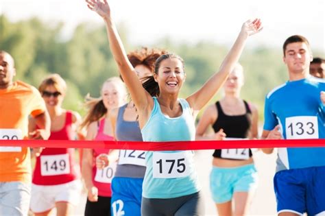 Sue Reynolds cruzando la meta de una maratón, con una sonrisa de satisfacción.