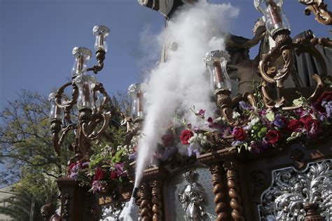 Fotografía artística de un detalle de un paso de Semana Santa, resaltando la orfebrería y las flores.