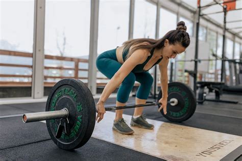 Mujer realizando un ejercicio de levantamiento de pesas en un box de CrossFit
