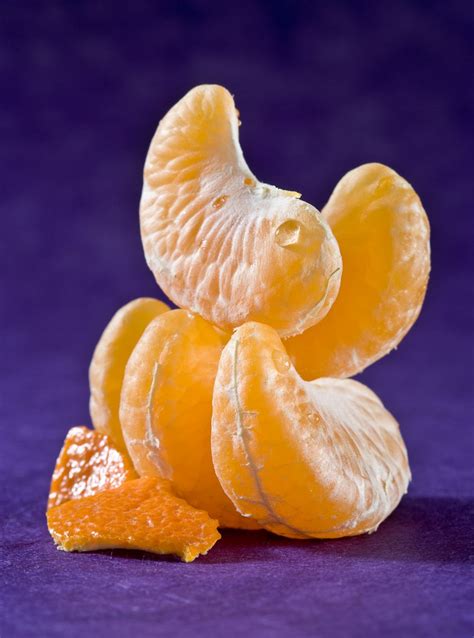 Primer plano de los gajos de una mandarina, con énfasis en la parte blanca (albedo) entre la cáscara y la pulpa.