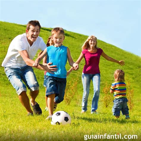 Foto de una familia sonriente jugando al aire libre con una pelota.