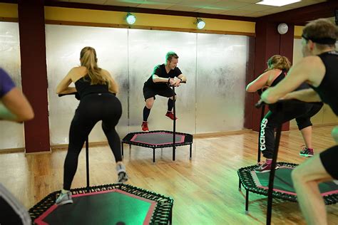 Grupo de personas participando en una clase de jumping fitness en un gimnasio