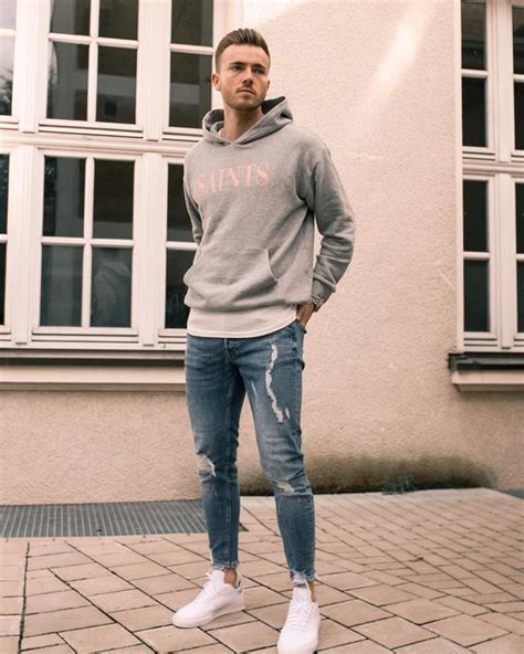 Hombre con vaqueros negros y sudadera, look juvenil