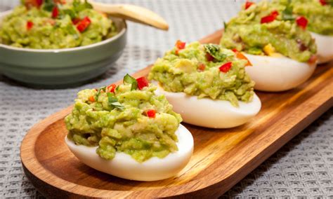 Imagen de huevos rellenos de guacamole decorados con cilantro fresco.