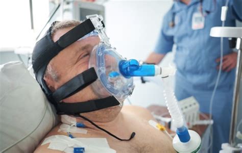 Ilustración de un paciente recibiendo ventilación mecánica no invasiva (VNI) con una mascarilla.