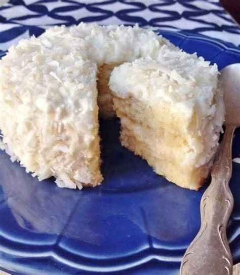 Imagen de un pastel de coco keto con relleno cremoso, decorado con coco tostado.