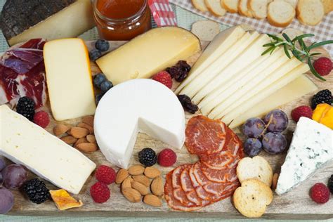 Fotografía de una tabla de quesos y embutidos europeos con mantequilla.