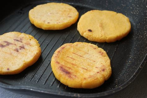 Fotografía de las arepas dorándose en un sartén.