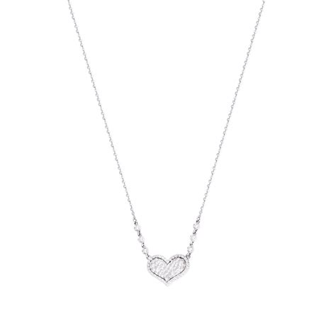 Diseño de un collar de oro blanco con un colgante de corazón adornado con circonitas.