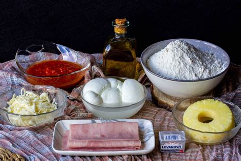 Ingredientes de la pizza hawaiana: base, salsa de tomate, queso mozzarella, jamón y piña