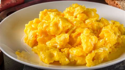 Infografía detallada de los beneficios nutricionales de los huevos revueltos, granola, pasas de uva y moras.