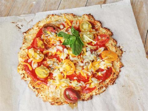 Fotografía de una pizza de coliflor keto terminada con diversos toppings.