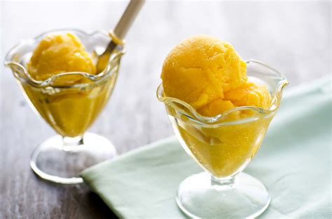 Un cuenco de sorbete de mango y banana vibrante y refrescante, con trozos de fruta fresca.