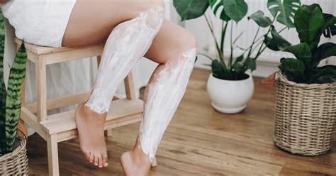 Mujer aplicándose crema reductora en las piernas